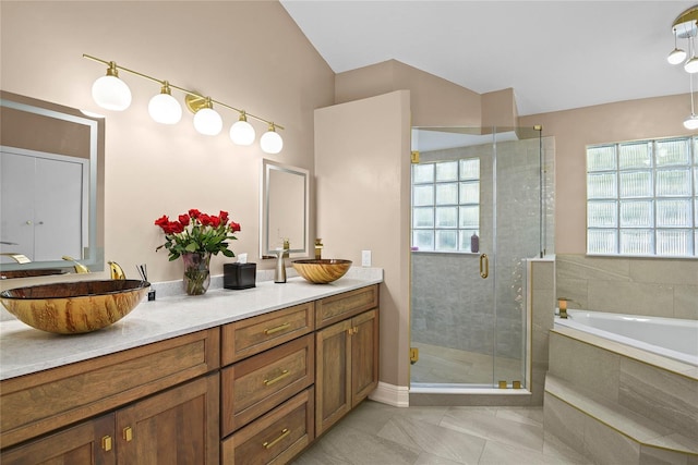 bathroom featuring plus walk in shower, vanity, and tile patterned floors