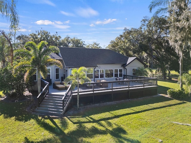 rear view of property featuring a lawn and a wooden deck