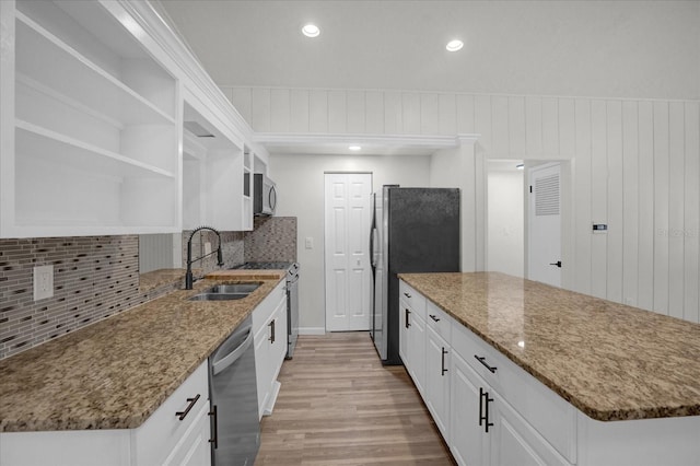 kitchen with decorative backsplash, light wood-type flooring, stainless steel appliances, sink, and white cabinets