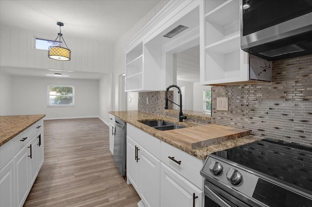 kitchen with white cabinets, pendant lighting, appliances with stainless steel finishes, and tasteful backsplash