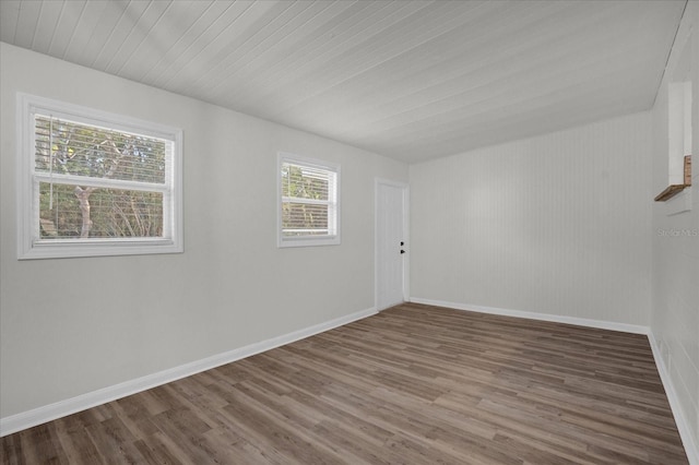 empty room with hardwood / wood-style floors and a healthy amount of sunlight