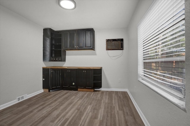 empty room featuring hardwood / wood-style flooring and a wall mounted AC