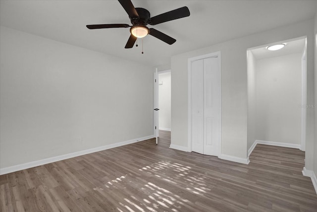 unfurnished bedroom featuring ceiling fan and dark hardwood / wood-style floors