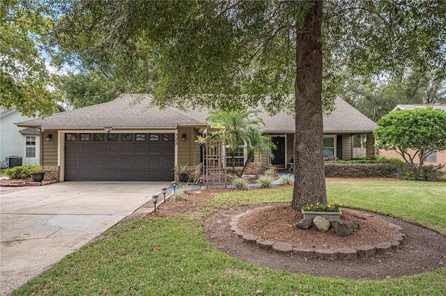 view of front of house with central AC, a garage, and a front lawn