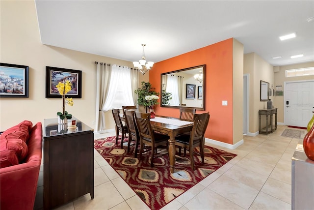 dining room with a chandelier and light tile patterned floors