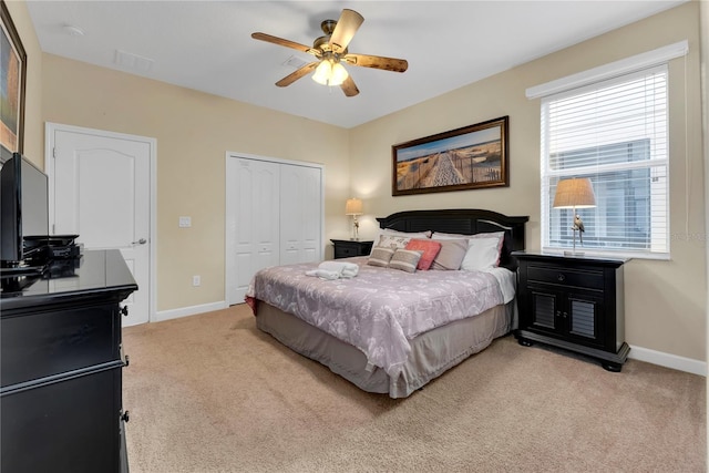 carpeted bedroom with ceiling fan and a closet