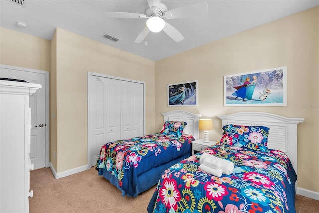 bedroom with ceiling fan, light carpet, and a closet