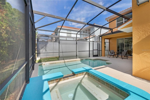 view of pool featuring an in ground hot tub, glass enclosure, and a patio area