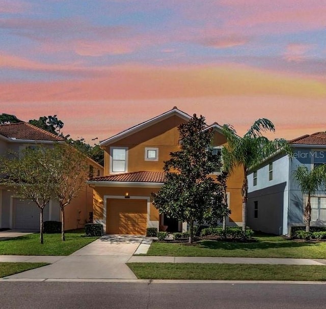 view of front of home with a garage and a lawn