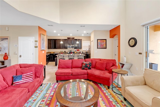 tiled living room featuring a towering ceiling