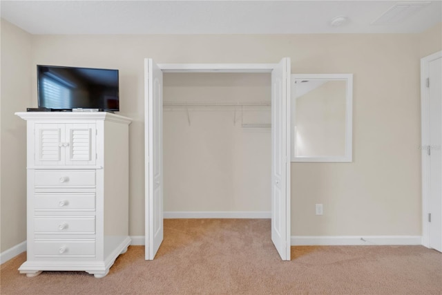 unfurnished bedroom featuring light colored carpet and a closet