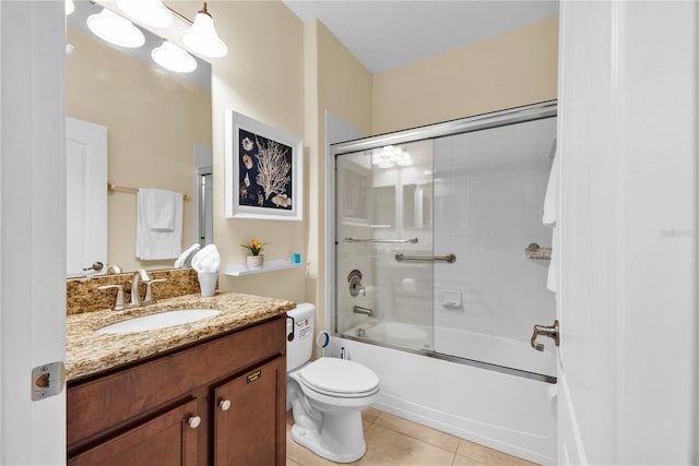 full bathroom featuring combined bath / shower with glass door, vanity, tile patterned floors, and toilet