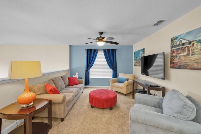 carpeted living room with a textured ceiling and ceiling fan