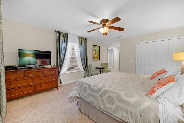 bedroom featuring ceiling fan, light carpet, and a closet