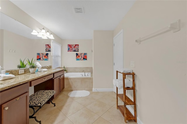 bathroom with tiled bath, tile patterned flooring, vanity, and an inviting chandelier