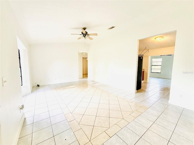 spare room featuring ceiling fan and light tile patterned flooring