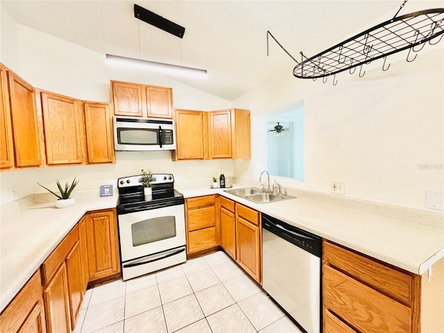 kitchen with sink, light tile patterned floors, vaulted ceiling, and appliances with stainless steel finishes