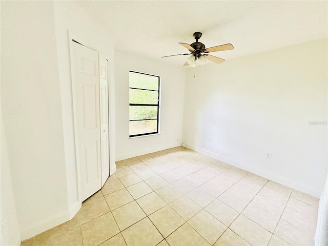 spare room with light tile patterned floors and ceiling fan