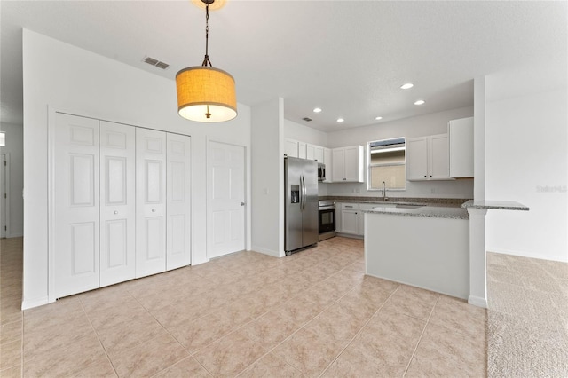 kitchen with white cabinets, appliances with stainless steel finishes, hanging light fixtures, kitchen peninsula, and light tile patterned floors