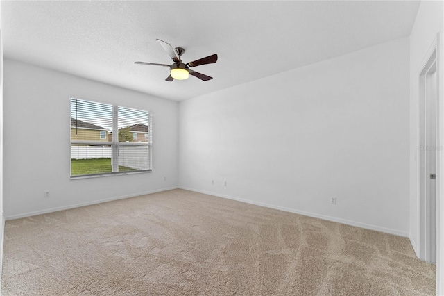 empty room featuring ceiling fan and light colored carpet