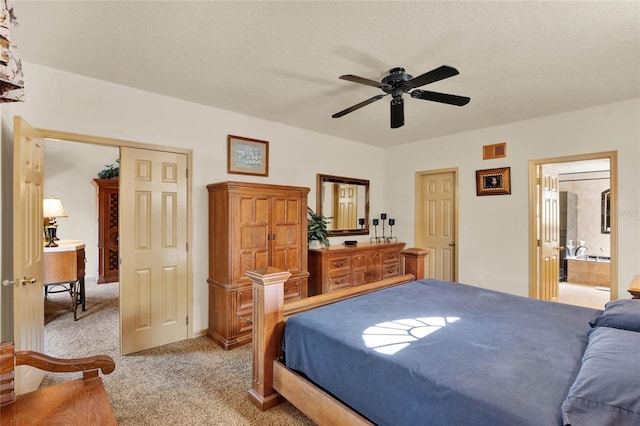 bedroom featuring ensuite bath, ceiling fan, light colored carpet, a textured ceiling, and a closet