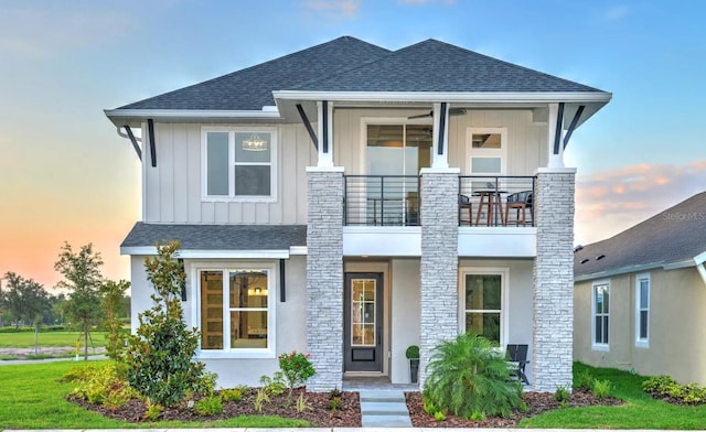 view of front of house with ceiling fan and a balcony