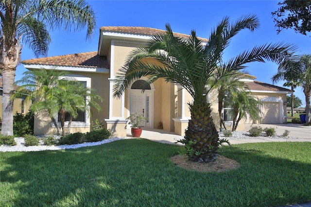 mediterranean / spanish home featuring a garage and a front lawn