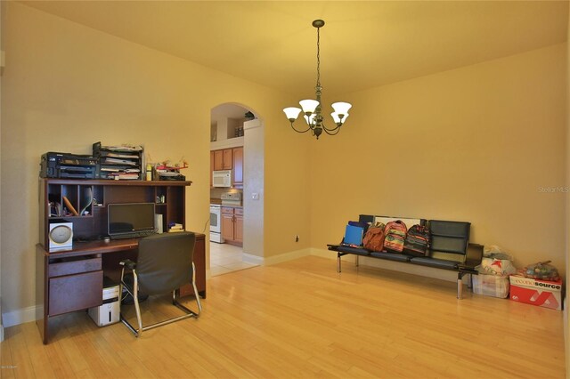 home office with light hardwood / wood-style floors and a chandelier