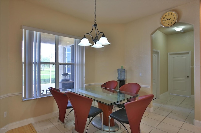 dining space featuring a healthy amount of sunlight, light tile patterned flooring, and an inviting chandelier