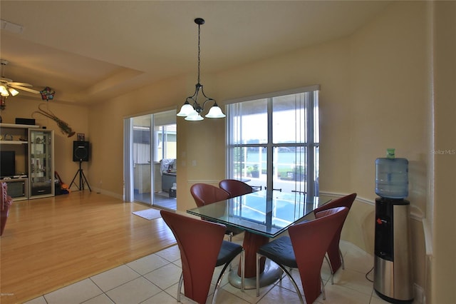 dining area with ceiling fan with notable chandelier and light hardwood / wood-style floors