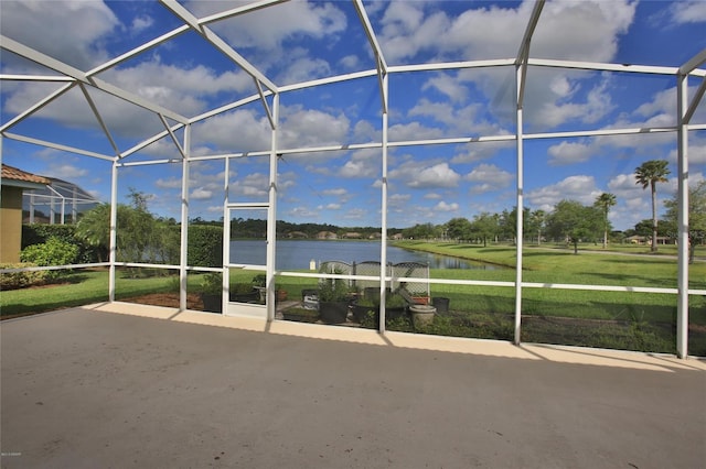 view of patio featuring a water view and glass enclosure