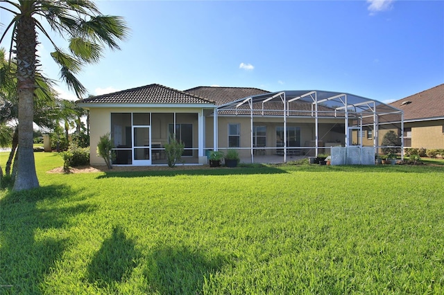 back of property with a lanai and a yard