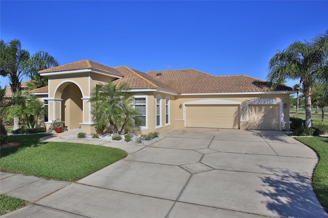 mediterranean / spanish-style home featuring a garage and a front yard