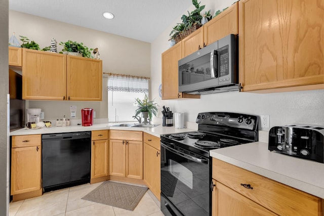 kitchen with sink, light tile patterned floors, black appliances, and light brown cabinets