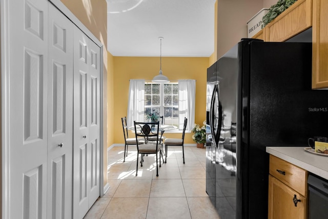 kitchen with light tile patterned floors, decorative light fixtures, and black appliances