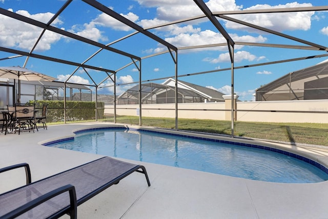 view of swimming pool with glass enclosure and a patio area