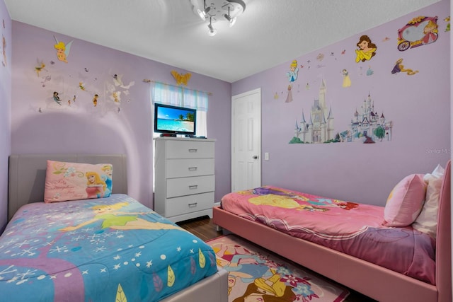 bedroom with hardwood / wood-style floors and a textured ceiling