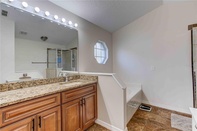 bathroom featuring vanity, independent shower and bath, and a textured ceiling