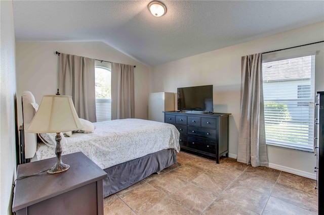 bedroom featuring a textured ceiling, multiple windows, and lofted ceiling