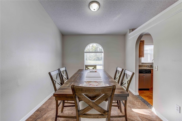 dining space with a textured ceiling, light hardwood / wood-style floors, and sink