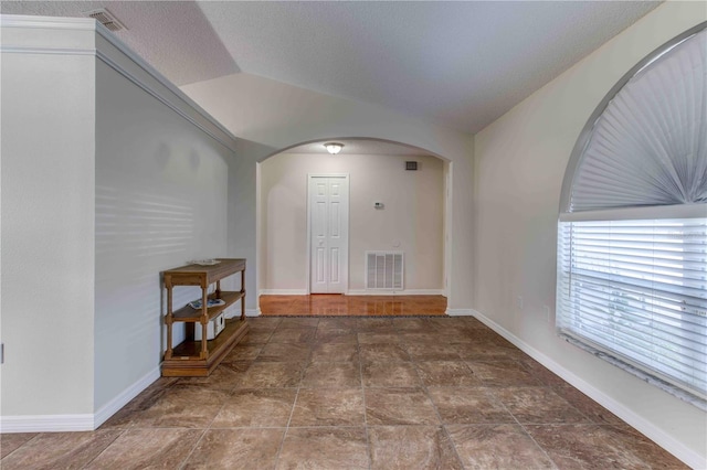 entrance foyer with a textured ceiling and vaulted ceiling