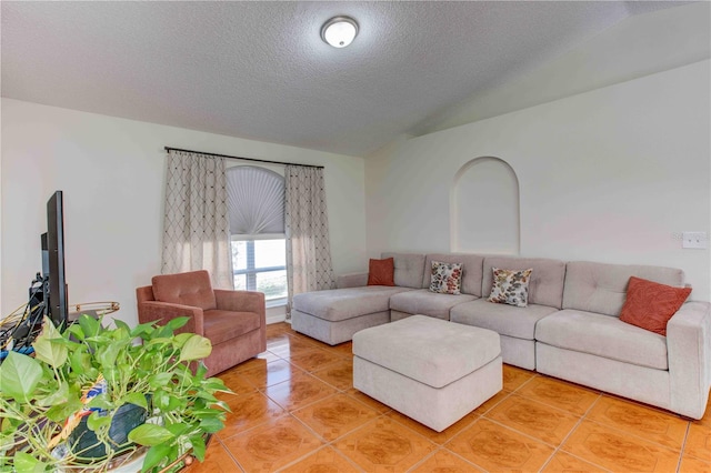 tiled living room featuring a textured ceiling