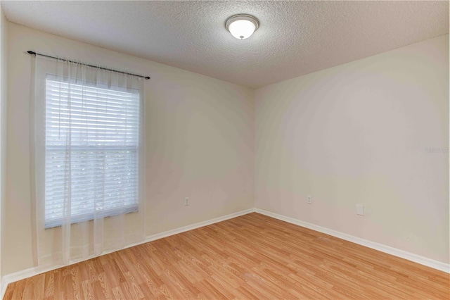 spare room with wood-type flooring and a textured ceiling