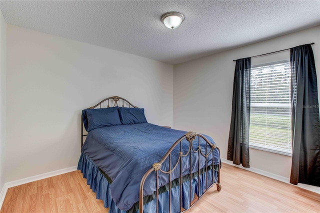 bedroom with hardwood / wood-style flooring and a textured ceiling