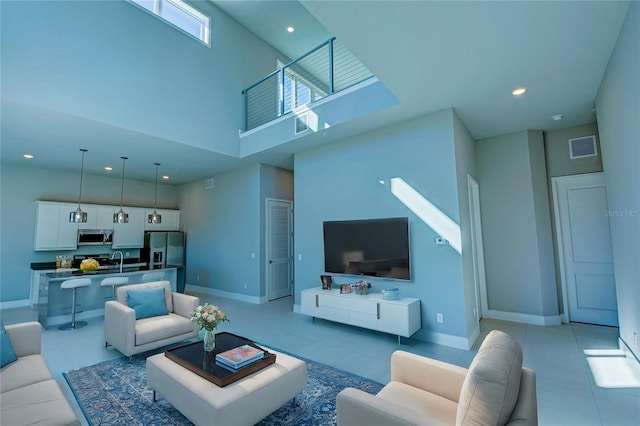 living room with light tile patterned floors and a high ceiling