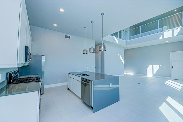 kitchen with white cabinets, sink, hanging light fixtures, an island with sink, and appliances with stainless steel finishes