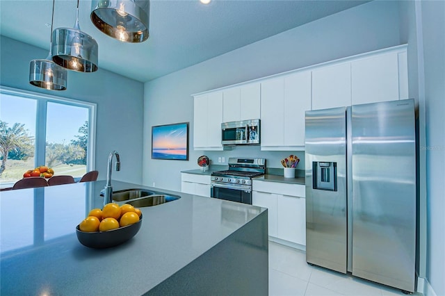 kitchen with white cabinets, stainless steel appliances, hanging light fixtures, and sink