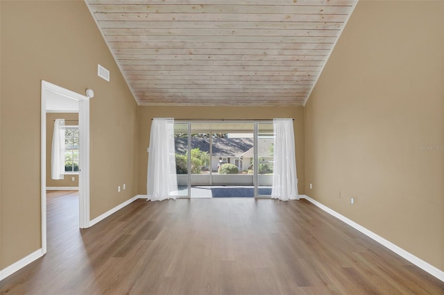 empty room featuring a mountain view, vaulted ceiling, wooden ceiling, and light hardwood / wood-style flooring