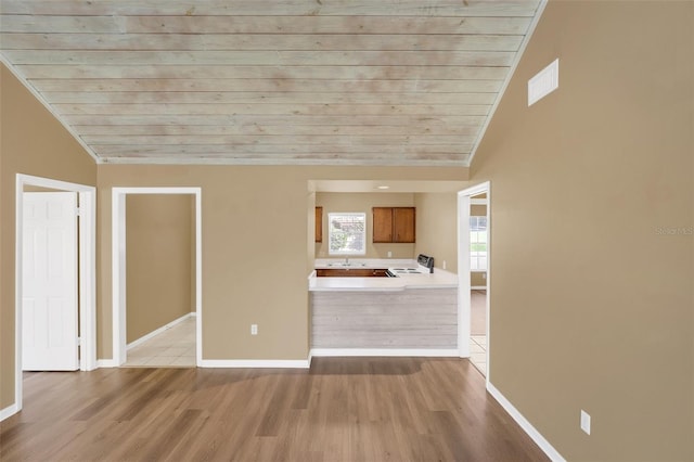 unfurnished living room featuring vaulted ceiling, light hardwood / wood-style flooring, and wooden ceiling