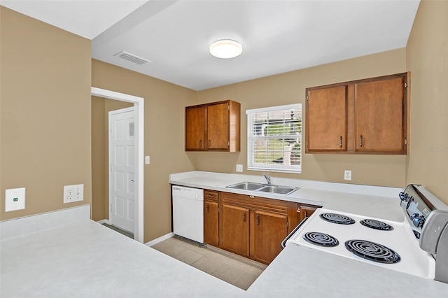 kitchen featuring light tile patterned floors, white appliances, and sink